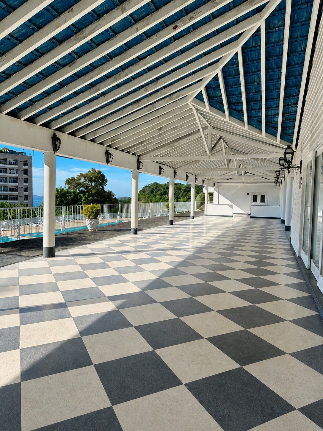 Varanda panorâmica do ALTO com piso xadrez e vista para o mar